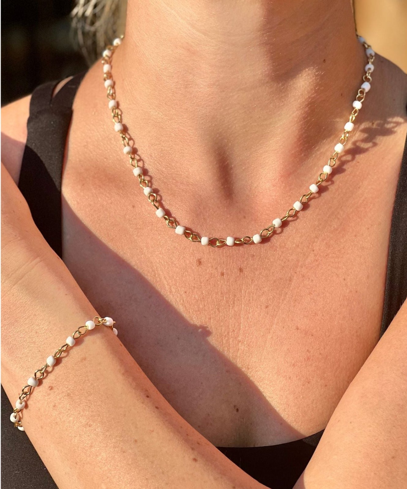 Necklace and bracelet set on a person's arm with a blurred background