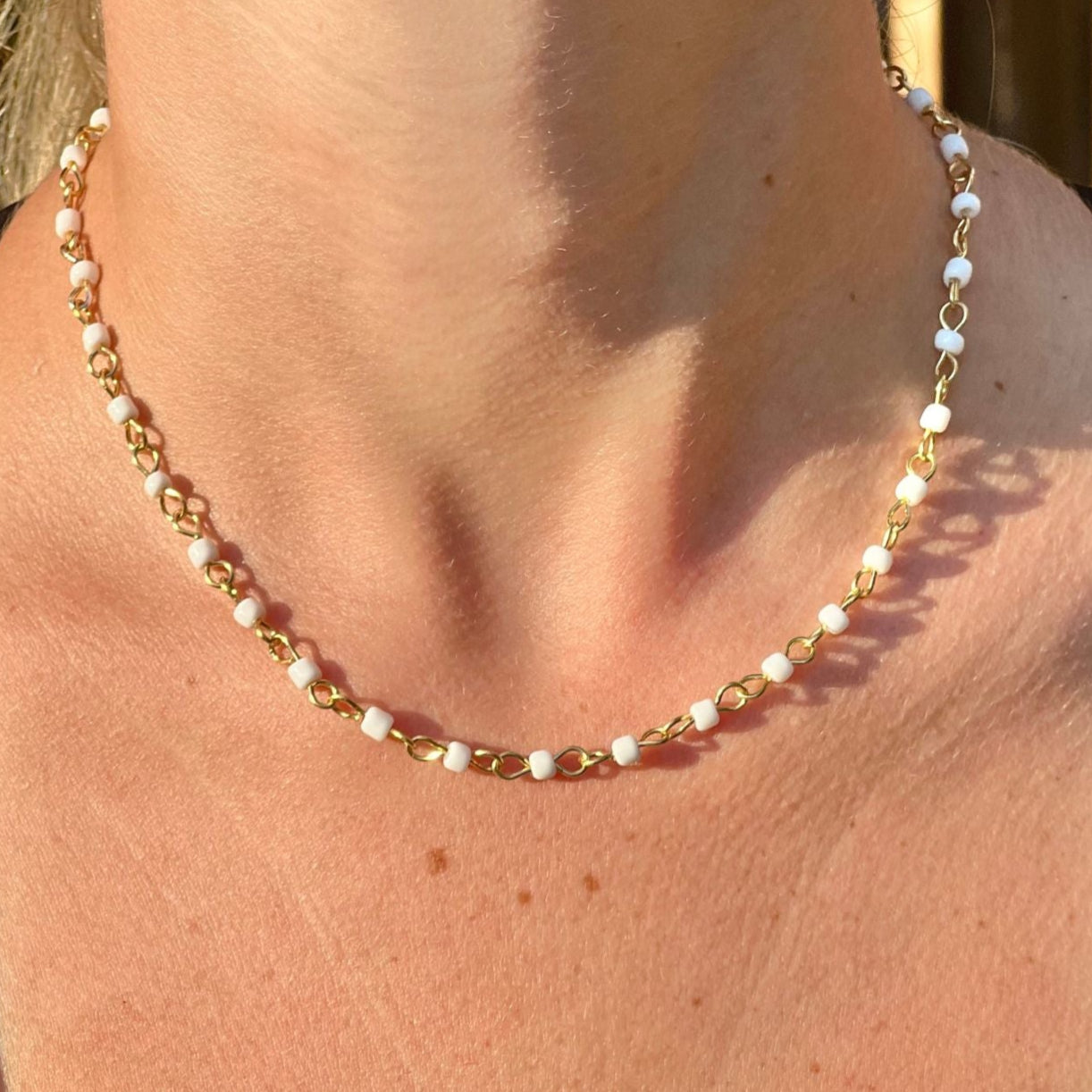 Necklace with small beads worn by a person