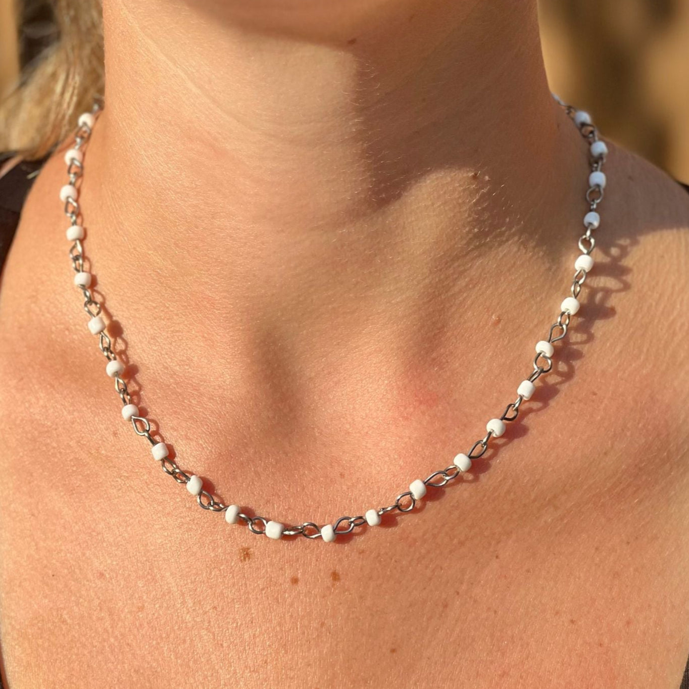 Necklace with small beads worn by a person